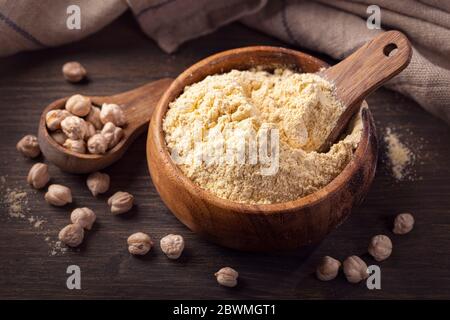Kichererbsenmehl in einer Holzschüssel auf weißem Hintergrund isoliert Stockfoto