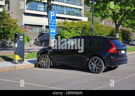 Neue Volvo XC Plug-in Hybrid-Elektro-SUV-Ladebatterie, Rückansicht, eingesteckt Helen Ladepunkt. Helsinki, Finnland. Juni 2020. Stockfoto