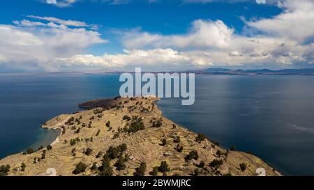 Luftaufnahme auf terrassenförmig angelegten Hängen der Insel Taquile am Titicaca-See mit anderen Inseln im Hintergrund. Der höchste schiffbare Seeblick der Welt. Stockfoto