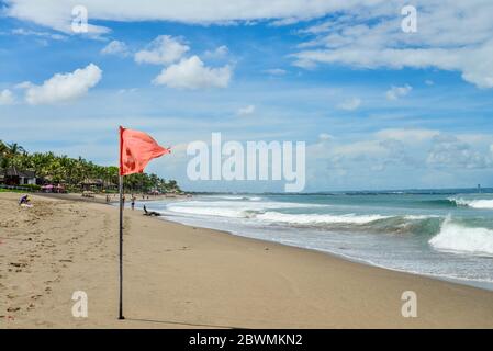 Bali, Indonesien - 2. April 2019 : Petitenget Beach in Seminyak mit roter Flagge an sonnigen Tagen, beliebter Sunset Beach in Bali, Indonesien Stockfoto