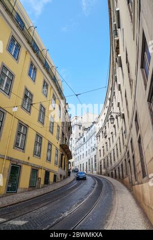 LISSABON, PORTUGAL - 4. JULI 2019: Enge Kopfsteinpflasterstraßen im Baixa-Viertel in Lissabon, Portugal Stockfoto