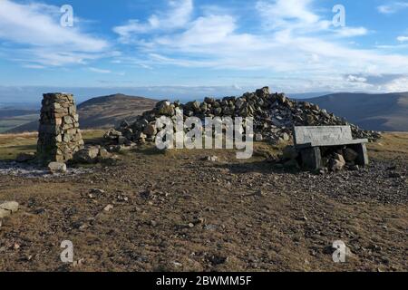 Trig-Säule und Bank auf dem Gipfel des High Pike in den Northern Fells des Lake District National Park - auf der Route des Cumbria Way Fernstrecken w Stockfoto