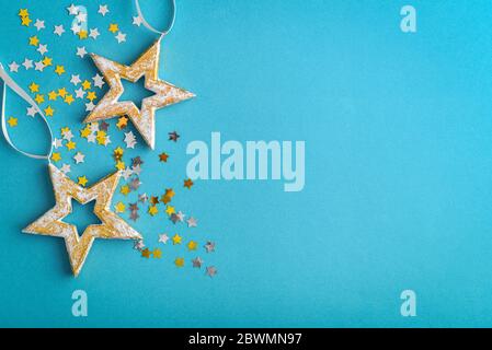 Weihnachtsschmuck in Form von Sternen auf blauem Hintergrund, Draufsicht Stockfoto