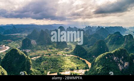 Luftaufnahme der Wolkenlandschaft über Dorf, Ackerland und Hügelwäldchen am Morgen Stockfoto