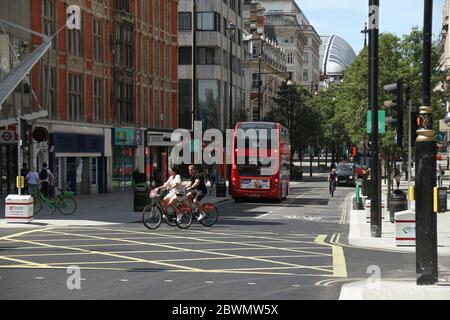 London, Großbritannien - 2. Juni 2020: Radfahrer fahren auf der Oxford Strete, wo trotz der Lockerung der Blockierung in England die Oxford Street nur wenig Fuß hatte, die meisten Geschäfte blieben geschlossen, aber für Lebensmittel. Einige nicht-wesentliche Geschäfte, Autohäuser und Outdoor-Märkte in Großbritannien konnten am 1. Juni aus ihrer COVID-19-Stilllegung wieder eröffnet werden, um die Lockdown-Maßnahmen des Coronavirus zu erleichtern. Foto: David Mbiyu/ Alamy News Live Stockfoto