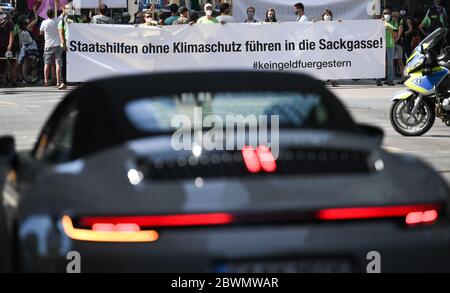 02. Juni 2020, Hessen, Frankfurt/Main: Mit Transparenten in den Händen, darunter auch mit der Aufschrift "staatliche Hilfe ohne Klimaschutz führt in eine Sackgasse", blockieren Demonstranten den Stoßverkehr auf der Neuen Mainzer Straße im Frankfurter Bankenviertel. Mehrere Initiativen und Umweltgruppen haben sich gegen die Prämien für den Autokauf und für eine Verkehrswende auf die Straße gemacht. Foto: Arne Dedert/dpa Stockfoto