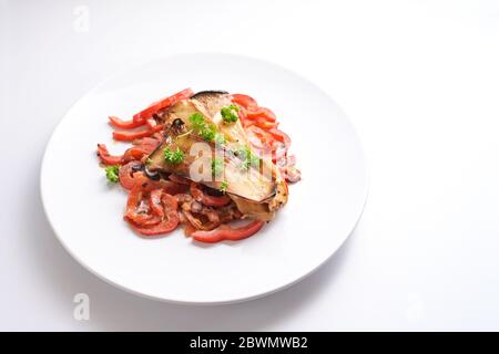 King Austernpilze und rote Paprika auf einem weißen Teller, gesundes Gemüsegericht für Low Carb Diät und Vegetarier, weißer Hintergrund mit Kopierraum Stockfoto