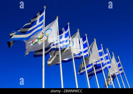 Griechische Flaggen und olympische Flaggen winken - Athen, Griechenland, 3. März 2020. Stockfoto