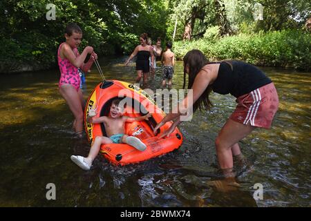 (Elterliche Erlaubnis erteilt) Billie, Boy und Maddison spielen im River Wandle im Morden Hall Park, Südlondon, während die Öffentlichkeit daran erinnert wird, nach der Lockerung der Lockdown-Beschränkungen in England soziale Distanzierung zu praktizieren. Stockfoto