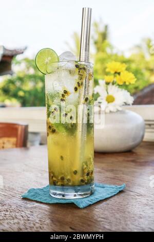 Passion Fruit Mojito Cocktail mit Metall Trinkhalm auf Holztisch im Café. Stockfoto