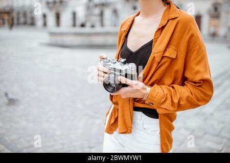 Frau mit Vintage-Kamera während der Reise in der Stadt, Nahaufnahme auf Kamera fokussiert Stockfoto