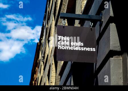 'This Cafe ends homelessness' Schild an der Fassade zum crisis Homeless Charity Cafe in Partnerschaft mit Volcano Coffee Works, Spitalfields, London, Großbritannien Stockfoto