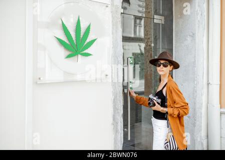 Frau, die auf Reisen mit Cannabis in ein Café oder ein Geschäft geht. Konzept der Legalisierung von Marihuana für den Tourismus Stockfoto