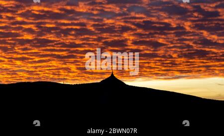 Silhouette des Jested Berges bei Sonnenuntergang mit einem wunderschönen beleuchteten Abendhimmel, Liberec, Tschechische Republik. Stockfoto