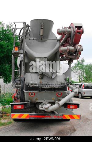 Ein Betonmischer LKW liefert Beton zu einer kleinen Baustelle im Nordosten Italiens. Es verwendet eine Drehtrommel, um die Zutaten zu mischen Stockfoto