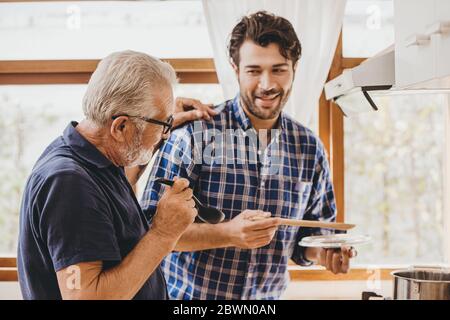 Glücklich älteren Mann genießen Kochen mit der Familie in der Küche für zu Hause bleiben Freizeitaktivitäten und Lebensstil der Menschen. Stockfoto