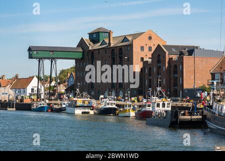 Wells Norfolk, Blick auf den Kai und ein wiederverwertungsvoller Getreidespeicher aus dem 19. Jahrhundert im Hafengebiet von Wells-next-the-Sea an der nördlichen Norfolk-Küste. Stockfoto