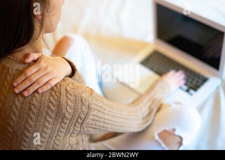 Büroangestellte mit Rückenschmerzen durch die Arbeit mit dem Computer. Ergonomie bei der Arbeit. Stockfoto