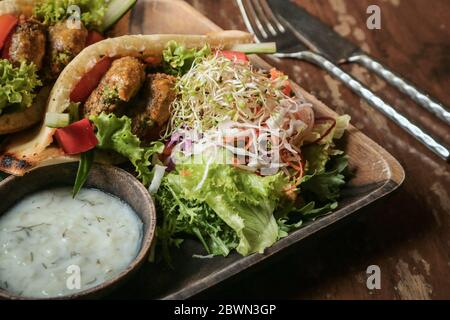 Falafel Pocket Pita. Mit Babaganoush, mit Krautsalat & Falafel serviert mit Beilage Salat & vegane Tzaziki. Stockfoto