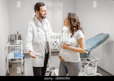Arzt mit schwangerer Frau während einer ärztlichen Konsultation in der gynäkologischen Praxis. Konzept der medizinischen Versorgung und Gesundheit während einer Schwangerschaft Stockfoto