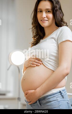 Porträt einer schönen jungen schwangeren Frau in einem gynäkologischen Büro. Konzept der Mutterschaft und der medizinischen Versorgung Stockfoto