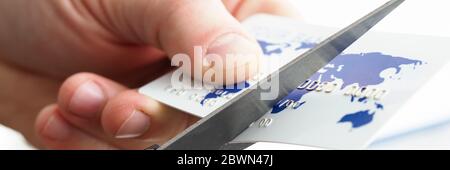 Männliche Hand schneiden Bankkarte mit Schere Stockfoto