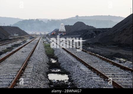 INDIEN Andhra Pradesh, Visakhapatnam, Verladeplatz für importierte Kohle aus Australien auf Eisenbahnwaggon für den Transport zu Stahlwerken, smal Hindu Tempel an Eisenbahngleis Stockfoto