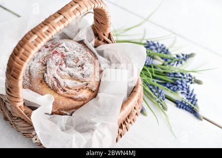 Osterkuchen auf dem Teller und Blumen auf Holzhintergrund Stockfoto