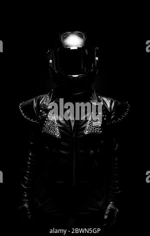 Porträt einer jungen Biker-Frau mit einer Nieten Lederjacke und einem schwarzen Helm Stockfoto