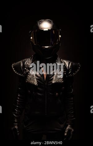 Porträt einer jungen Biker-Frau mit einer Nieten Lederjacke und einem schwarzen Helm Stockfoto