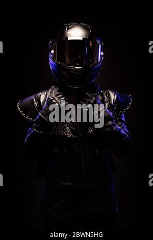 Porträt einer jungen Biker-Frau mit einer Nieten Lederjacke und einem schwarzen Helm Stockfoto