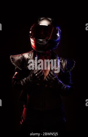 Porträt einer jungen Biker-Frau mit einer Nieten Lederjacke und einem schwarzen Helm Stockfoto