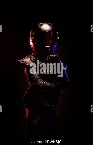Porträt einer jungen Biker-Frau mit einer Nieten Lederjacke und einem schwarzen Helm Stockfoto