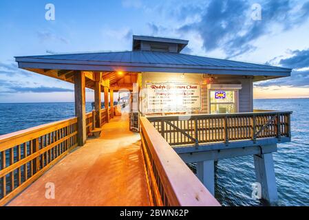 FORT MYERS, FLORIDA - FEBRUAR 2016: Fort Myers Pier bei Nacht mit Sonnenuntergang Farben. Stockfoto