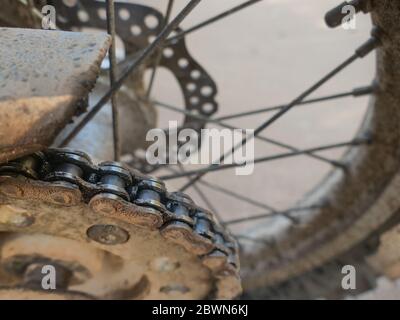 Nahaufnahme schmutzige Motorradkette und Sproket auf Enduro-Fahrrad. Stockfoto
