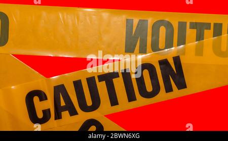 Gelbe Warnstreifen kreuzen sich. Isoliert. Roter Hintergrund. Schutz vor Viren, Bakterien und Keimen. Quarantänebereich. Polizeibarriere. Stockfoto