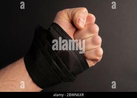 Faust mit einer schwarzen Maske in der Hand auf schwarzem Hintergrund. Ein Symbol für Protest und Unruhe in den Vereinigten Staaten gegen Gewalt und Ungerechtigkeit. Schwarz Li Stockfoto