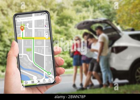 Geocaching-Konzept. Frau, die Smartphone mit gps-App auf dem Bildschirm, Menschen, die auf Karte im verschwommenen Hintergrund Stockfoto