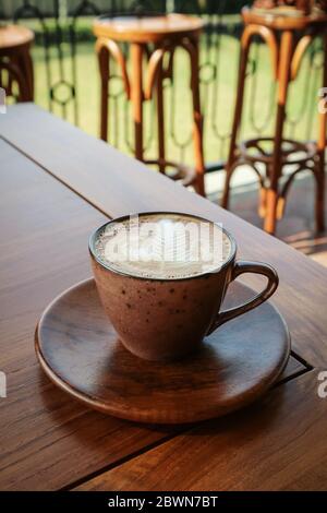 Eine Tasse Kaffee mit Latte Art auf Holztisch Stockfoto