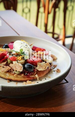 Pfannkuchen mit Banane, Kiwi, Erdbeeren und Eis auf einem Teller, Nahaufnahme Stockfoto