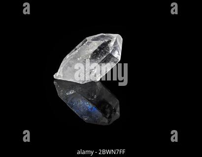 Transparentes Quarzkristall mit blauer Reflexion, isoliert auf schwarzem Hintergrund Stockfoto