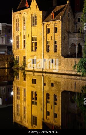 UGES, BELGIEN - 9. JUNI 2017: Alte Gebäude im Stadtzentrum spiegeln sich nachts im Wasser der Kanäle. Stockfoto