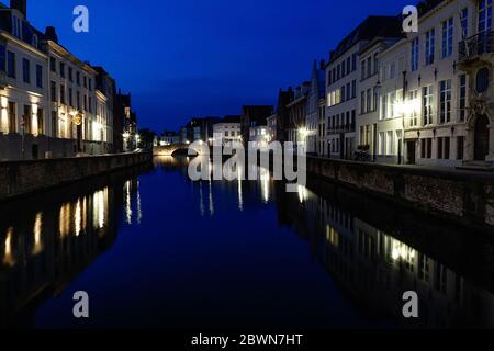 UGES, BELGIEN - 9. JUNI 2017: Alte Gebäude im Stadtzentrum spiegeln sich nachts im Wasser der Kanäle. Stockfoto