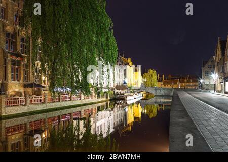 UGES, BELGIEN - 9. JUNI 2017: Alte Gebäude im Stadtzentrum spiegeln sich nachts im Wasser der Kanäle. Stockfoto