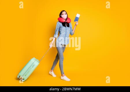 Ganzkörper-Profil Seite positive Student Mädchen halten Dokumente Tasche Gepäck bereit Reise gehen Check-in tragen medizinische Maske weichen Hals Kissen Denim Jeans-Shirt Stockfoto