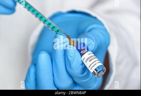 Hand in blauen Handschuhen hält Spritze und Coronavirus-Impfstoff (Aufkleber eigenes Design, Dummy-Daten), über es Nahaufnahme Detail zu injizieren. Covid-19-Kur-Konzept Stockfoto