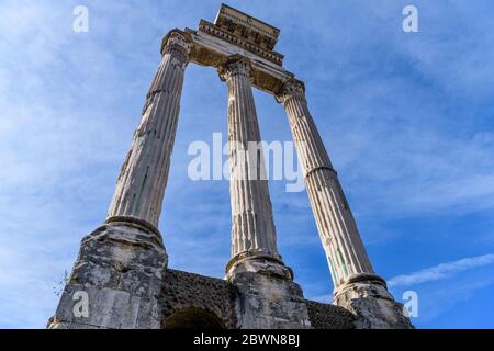 Ruinen des römischen Tempels - Low-Winkel-Ansicht von drei korinthischen Marmorsäulen und einer restlichen Entablatur des Tempels von Castor und Pollux im römischen Forum. Stockfoto