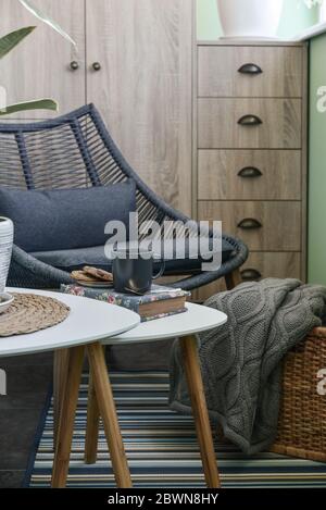 Interieur des gemütlichen Balkon mit grünen Wänden, Sitzecke mit Teppich, Sessel und zwei Couchtische Stockfoto