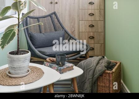 Interieur des gemütlichen Balkon mit grünen Wänden, Sitzecke mit Teppich, Sessel und zwei Couchtische Stockfoto