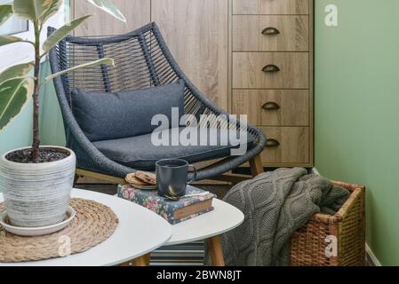 Interieur des gemütlichen Balkon mit grünen Wänden, Sitzecke mit Teppich, Sessel und zwei Couchtische Stockfoto